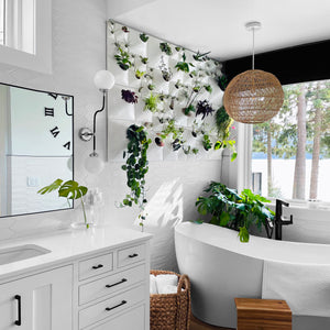 A selection of Node Wall Planters installed in a sunny bathroom with tile walls and a hanging lamp.