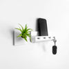 Cute wall planter next to cell phone holder in modern home.
